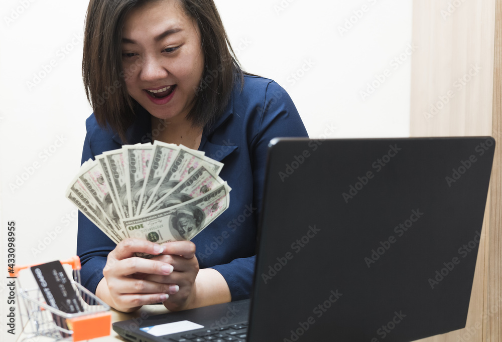 Smart woman in blue work clothes holds money several banknotes in her expressions of joy. Concept of selling merchandise or doing business online. e-commerce. Smart woman in blue work clothes holds money several banknotes in her expressions of joy. Concept of selling merchandise or doing business online. e-commerce.