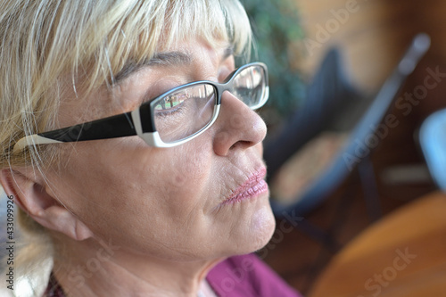 Portrait of a sad mature blonde woman in reflexion