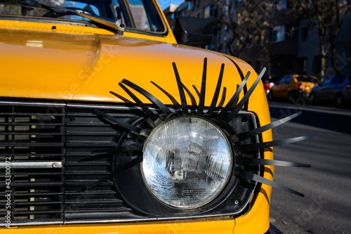 Details of an light from an old yellow car decorated on street in Bucharest, Romania.