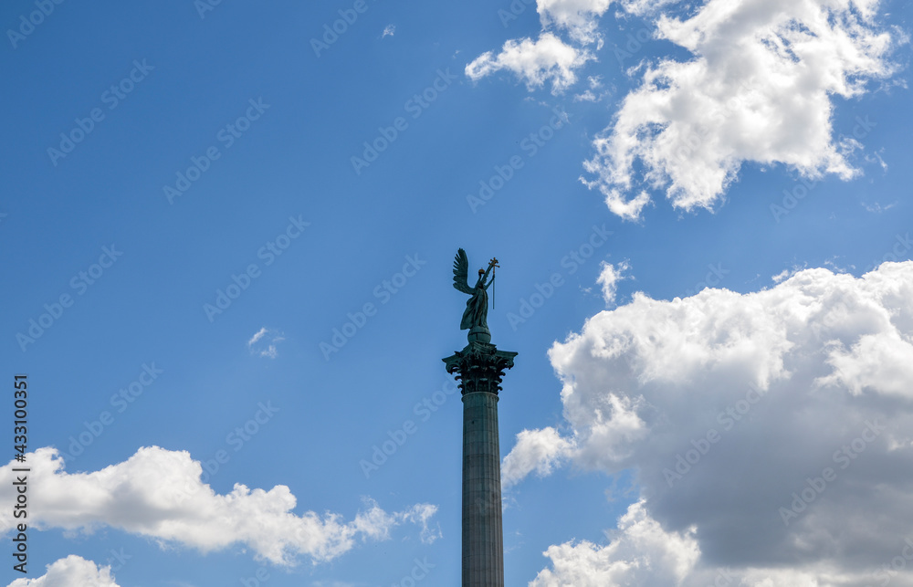 Archangel Gabriel at the top of the Corinthian column on cloudy sky background at Heroes Square. Budapest, Hungary 