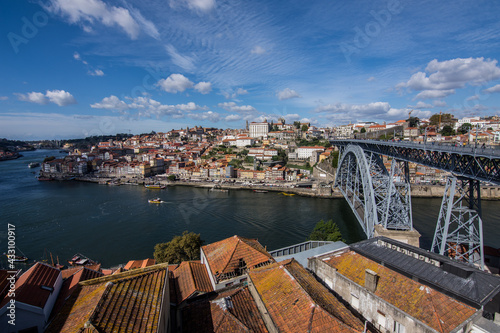 View of La Ribeira and the Don Luis I bridge in the city of Porto on a sunny day.