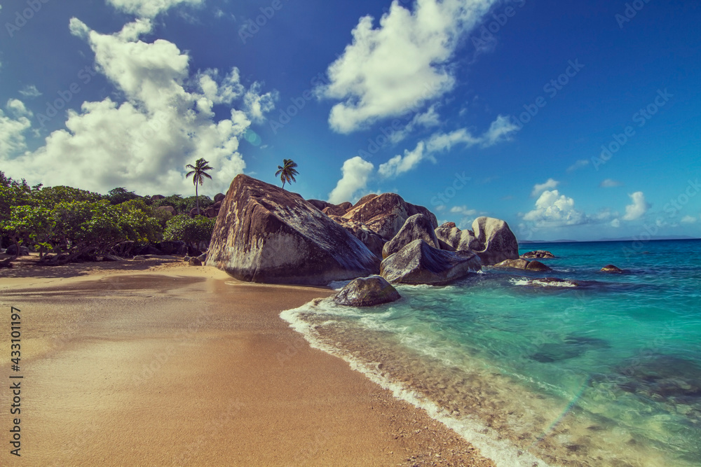 Felsen Felswand mit Vegetation und Palmen am Strand und Meer unter strahlend blauem Himmel und türkises Wasser in der Karibik Hawaii USA