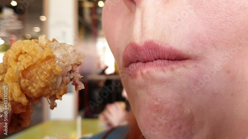 40 years old woman eats fried chicken in fast food, high-calorie food is harmful to the body