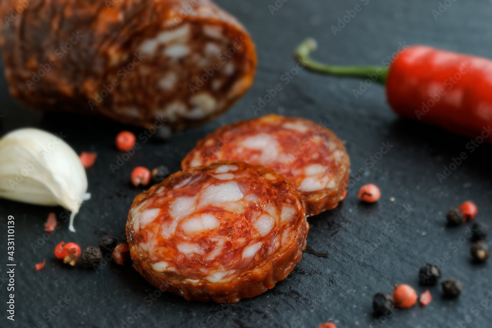 Close up of a spicy salami sliced on a slate board