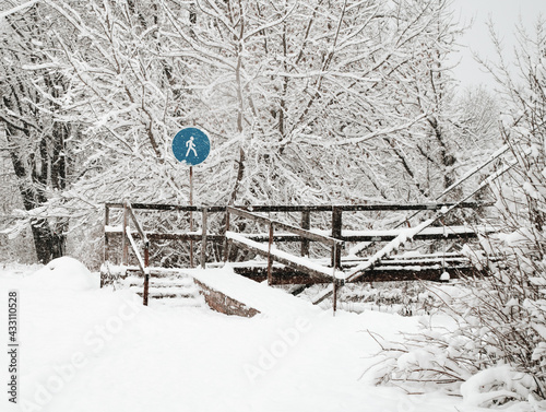 in winter, the snow-covered sign is blue against the cold