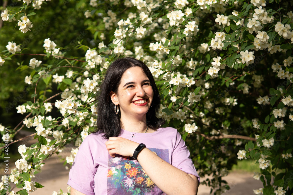Photo of an attractive woman with black hair in the middle of nature during spring time, walking around and smiling during a sunny day Photo of an attractive woman with black hair in the middle of nature during spring time, walking around and smiling during a sunny day