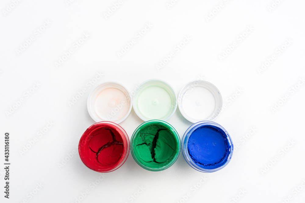 Set of jars of dry gouache paints, top view, close-up, white background, copy space Set of jars of dry gouache paints, top view, close-up, white background, copy space
