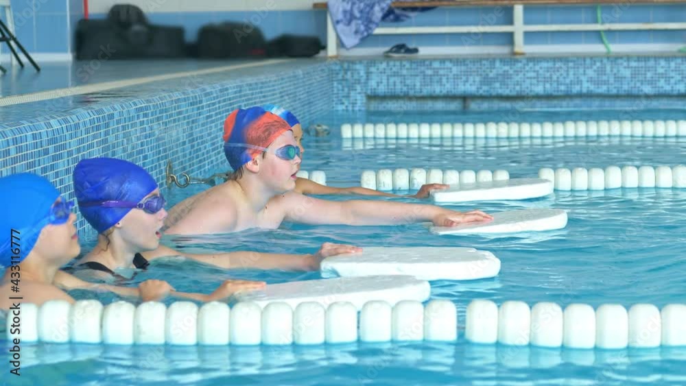 Vídeo do Stock Children learn to swim with the help of a swimming