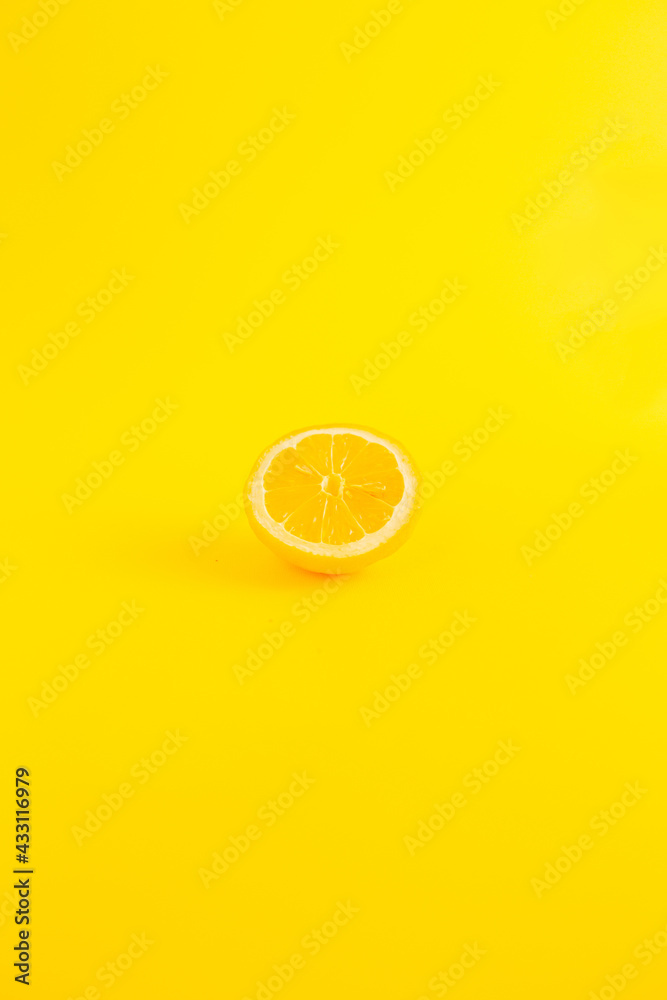 Fototapeta Lemon on a illuminate yellow background. Minimalist depiction of summer fruit. Neon yellow color is in trend. Pastel colors are popular. Take care of yourself and eat fruit. Summer is coming.