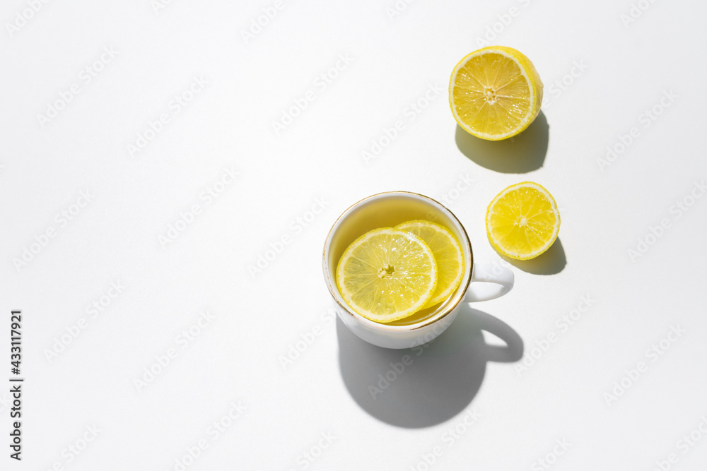 Cup of lemon tea and fresh lemon, white background, copy space, top view Cup of lemon tea and fresh lemon, white background, copy space, top view