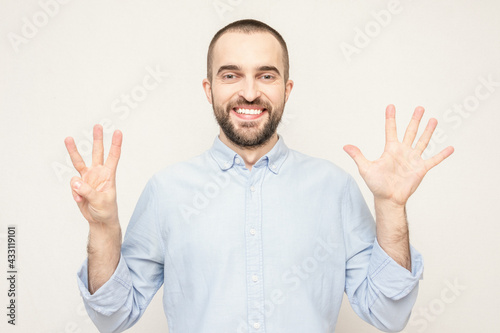  Happy bearded shows eight fingers up, white background