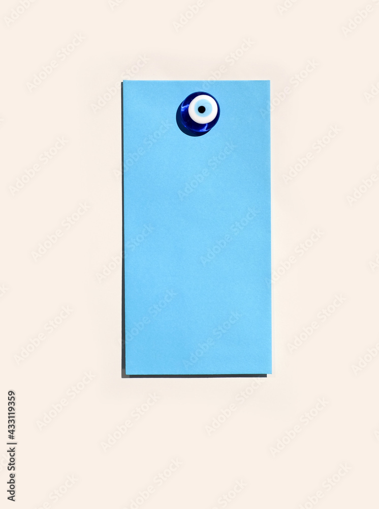 Blue envelope mock-up on magnetic board with glass evil eye magnet Blue envelope mock-up on magnetic board with glass evil eye magnet