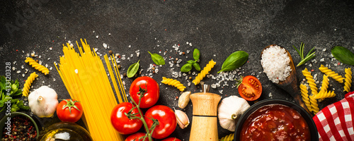 Italian food background. Pasta, olive oil, tomato sauce, spices, basil and fresh tomatoes. Long banner format.