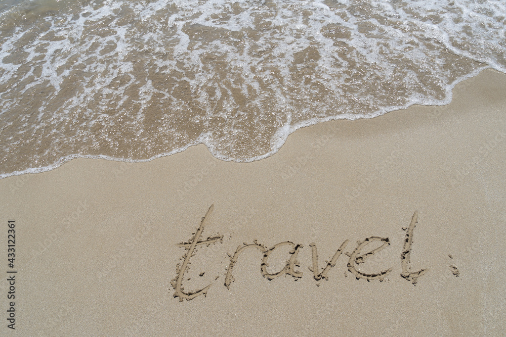 Fototapeta premium travel written in fine sand on the beach