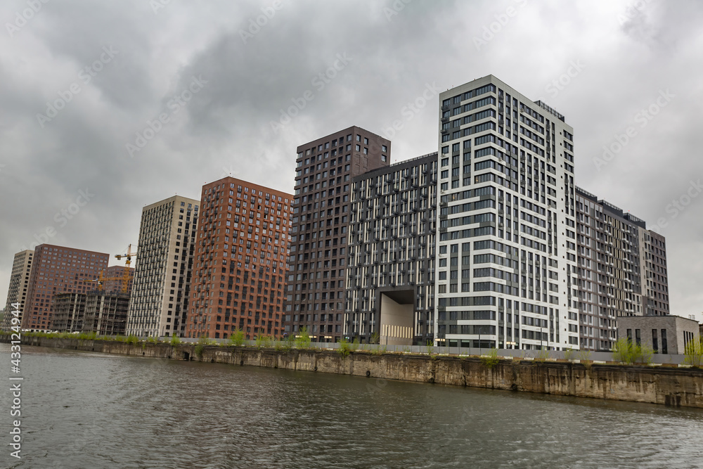 Residential buildings on the banks of Moskva River on a cloudy day. Housing construction according to the city renovation program. Moscow, Russia Residential buildings on the banks of Moskva River on a cloudy day. Housing construction according to the city renovation program. Moscow, Russia