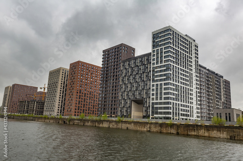 Residential buildings on the banks of Moskva River on a cloudy day. Housing construction according to the city renovation program. Moscow, Russia