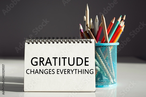 Gratitude changes everything - inscription on a notebook with colored pencils photo