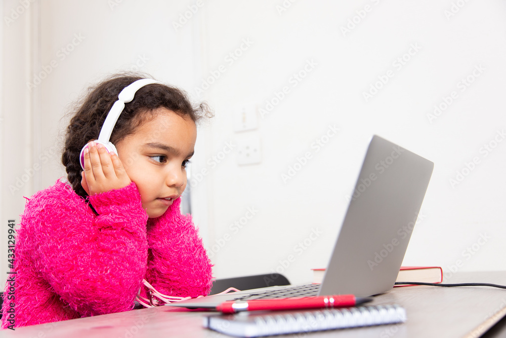 Smart schoolgirl doing her homework with laptop at home. Distance education and learning for children. Homeschooling during quarantine. Smart schoolgirl doing her homework with laptop at home. Distance education and learning for children. Homeschooling during quarantine.
