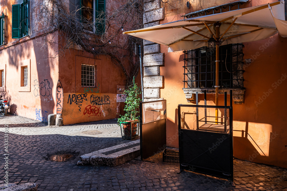 Cozy colorful street in the Trastevere district, Rome. Trastevere is a romantic district of Rome, along the banks of the Tiber, famous for its local pizzerias and nightlife where the Romans meet.