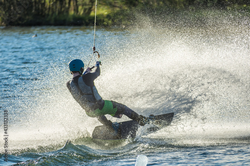 Man water wakeboarding skiing at sunset. photo