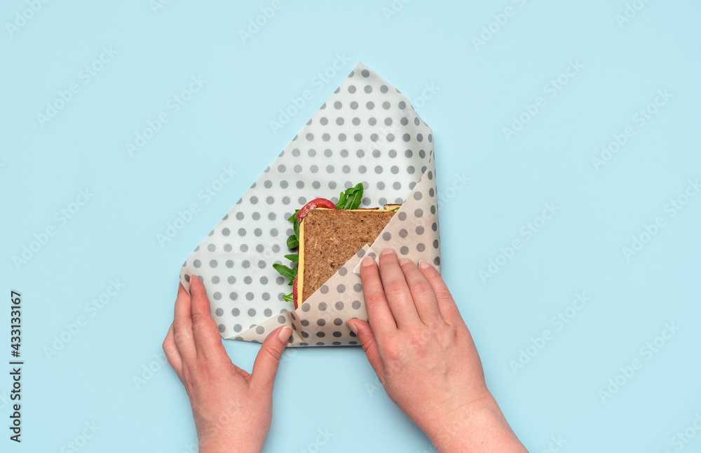 Wrapping sandwich in a beeswax cloth, top view. Ethical consumerism. Wrapping sandwich in a beeswax cloth, top view. Ethical consumerism.