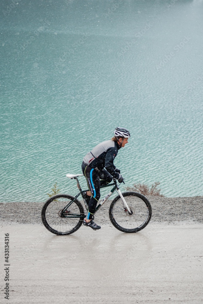 man riding a single speed mountain bicycle above lake
