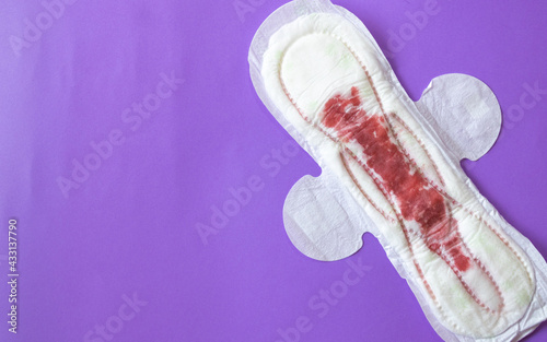Fotografie feminine sanitary napkin with blood simulation, on a purple plain background