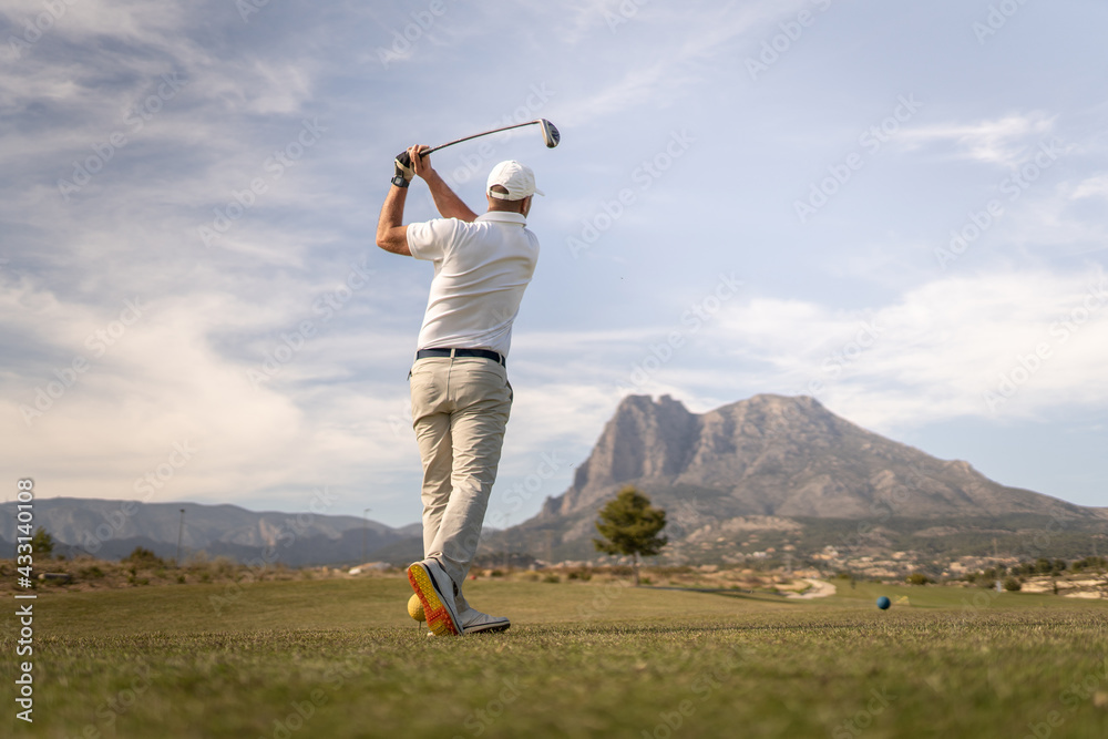 Golf player making a perfect swing on the golf course in the sunset. Golf player making a perfect swing on the golf course in the sunset.