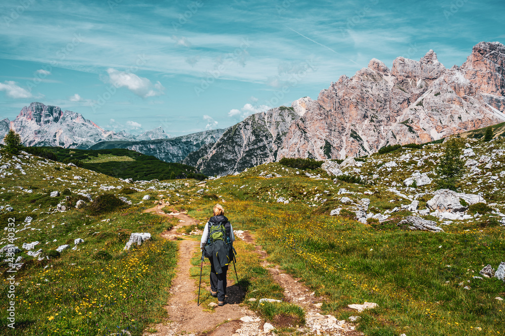 Backpacker on hiking trails in the Dolomites, Italy.