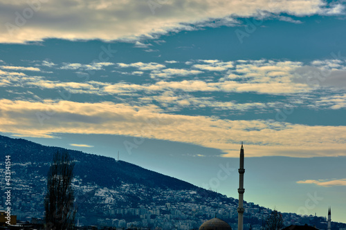 Dramatic sky in Bursa with ulu mountain (uludag) overcast sky and mosque and minaret. photo