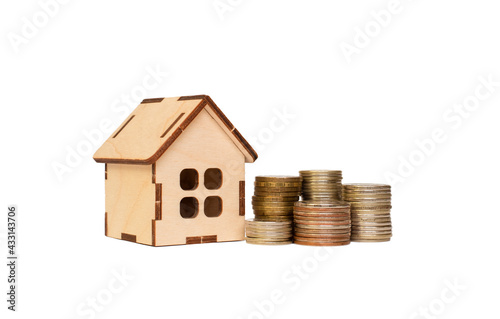 wooden house and towers from coins on a white background.