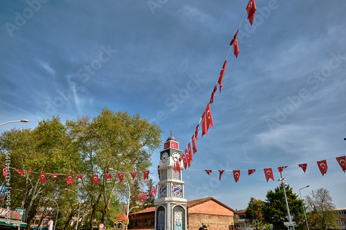 Center of the iznik city with sculpture covered by iznik tiles and hagia sophia and its minaret and cycling people background during sunny day. . Nicea (iznik), Bursa Turkey. photo