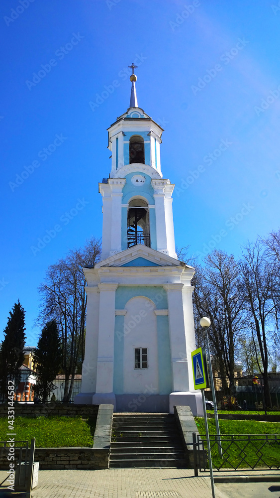 Two-tiered bell tower of Church of the Assumption of the Blessed Virgin Mary located in Pskov city, Russia. Ancient old building. Historical architecture. Blue sky. Travel destination. Vertical view.