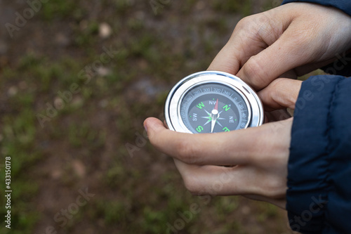 Selective focus of a detail of a girl's hands holding a compass