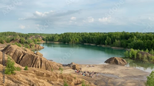 A large company on a picnic on the shore of a beautiful lake