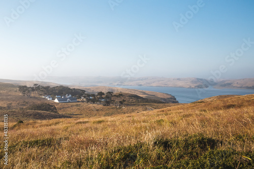 Ranch and grassy hills under a blue sky in Tomales Bay, California