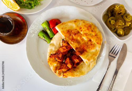 Appetizing spicy chicken shish taouk (Sis tavuk) served with lavash and vegetables. Traditional Turkish cuisine