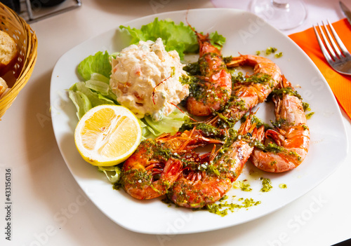 Image of delicious king shrimps and salad from potatoes at plate