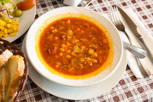 Spanish soup cooked chickpeas, pepper and beef tripe, served at white bowl