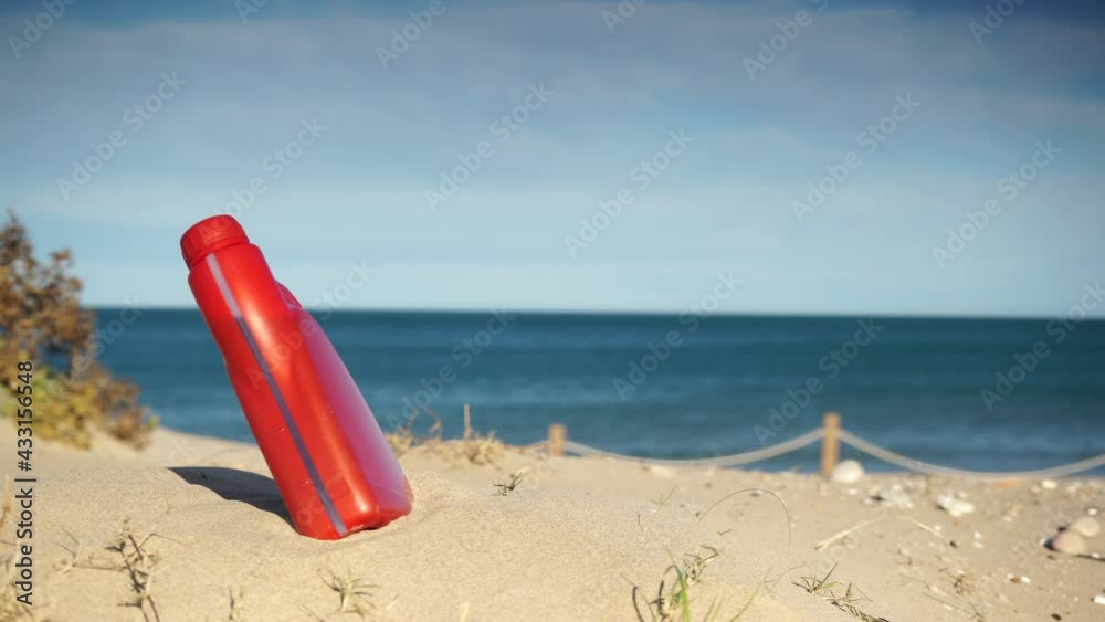 Polluted beach shore. Engine oil plastic chemical bottle abandoned on sand, sea in the background. Environmental pollution global ecological problem. Polluted beach shore. Engine oil plastic chemical bottle abandoned on sand, sea in the background. Environmental pollution global ecological problem.