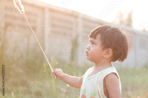 child blowing dandelion