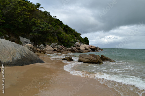 beach with pareia and rocks with cloudy sky