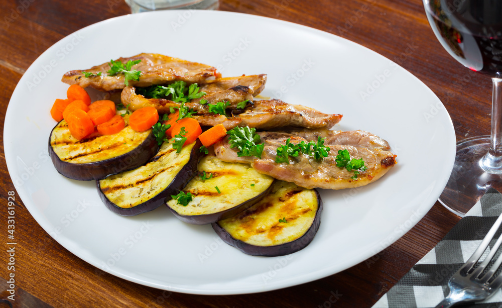 Delicious slices of roasted lamb meat served with grilled eggplant, carrot and herbs
