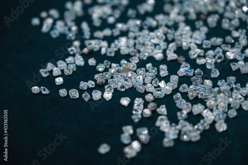 Small transparent diamonds are scattered on the blue velvet. Pure, rough diamonds
