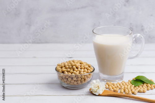 Soy and soy milk in a glass with soybeans in wooden bowl background © Keopaserth