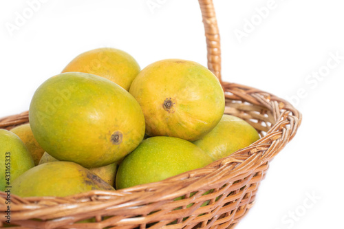 indian mangos in a basket on a white background in close up view