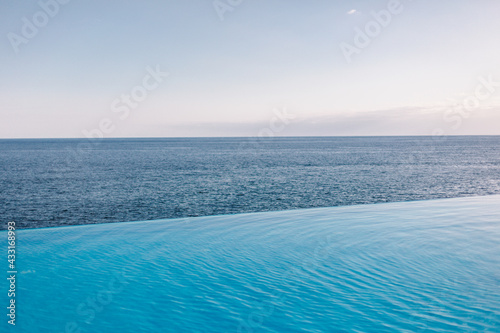 Infinity pool, sea and blue sky on background. Just relax and chill. Nobody. Clear horizon. 