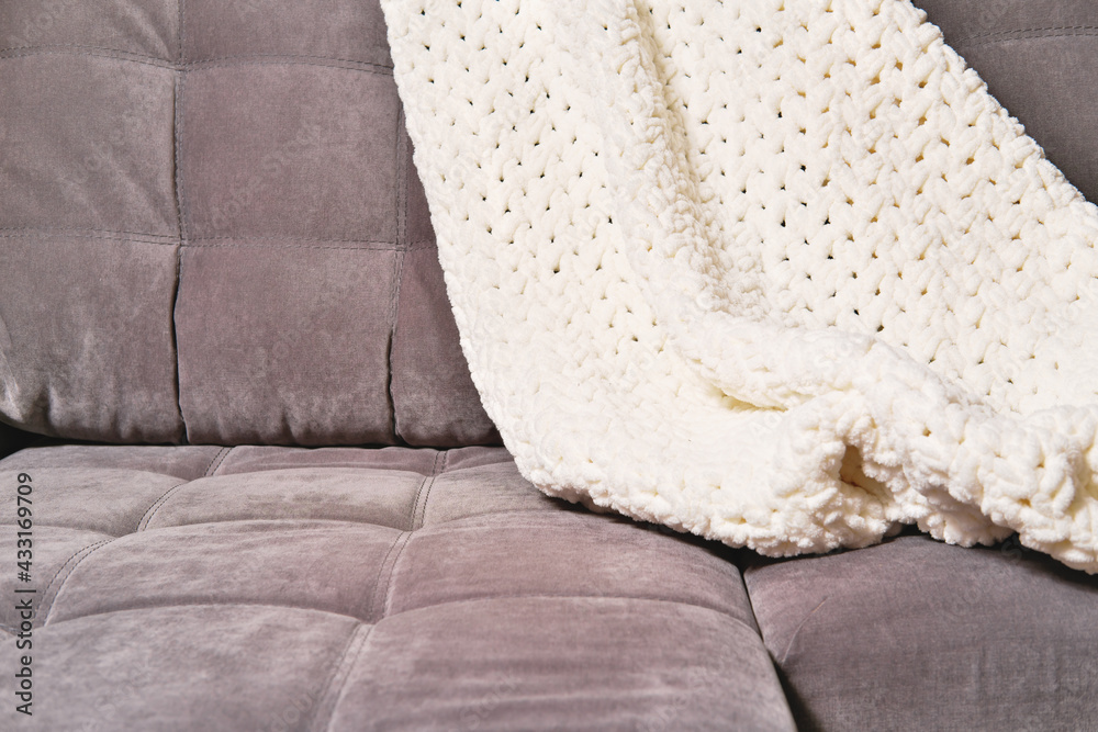 cozy plaid or knitted blanket on a modern sofa. cosy home concept. relaxing  me-time, calm place to get rest and for stress relief. mind balance and  inner peace Photos | Adobe Stock