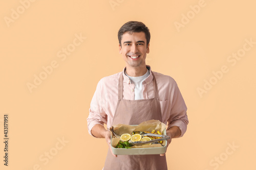 Young man with baking dish ...