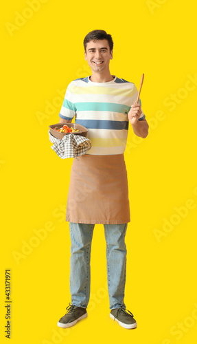 Young man with baking dish ...